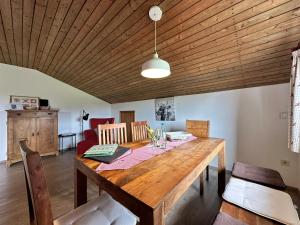 ein Esszimmer mit einem Holztisch mit Stühlen in der Unterkunft Ferienwohnung am Richterbichl in Rottenbuch