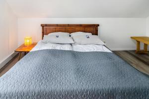 a bed with a wooden headboard and two pillows at Fewo3 Buppeape Saterland in Bollingen