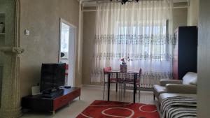sala de estar con sofá y mesa en A nicely furnished, cozy apartment located in the center of the city with complimentary Mongolian traditional meal upon your arrival en Ulán Bator