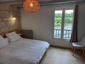 a bedroom with a bed and a large window at Agréable maison de ville au coeur de Chinon in Chinon