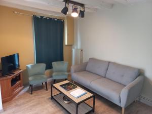 a living room with a couch and two chairs and a tv at Agréable maison de ville au coeur de Chinon in Chinon