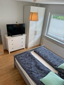 a bedroom with a bed and a tv and a dresser at Exklusives Apartment Nähe Attendorn und Olpe für 6 Personen mit Dachterasse in Attendorn