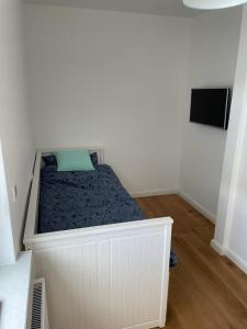 a small bedroom with a bed with a green pillow at Exklusives Apartment Nähe Attendorn und Olpe für 6 Personen mit Dachterasse in Attendorn