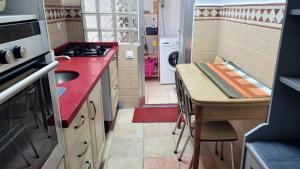 Una pequeña cocina con una encimera roja y un fregadero. en Apartment Turquesa - Almería, en Almería