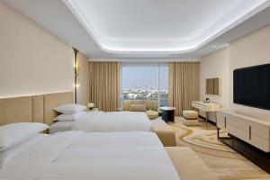 Habitación de hotel con 2 camas y TV de pantalla plana. en Grand Hyatt Dubai en Dubái