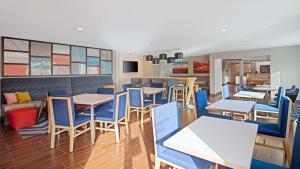 a dining room with tables and blue chairs at Hampton Inn Phoenix Airport North in Phoenix