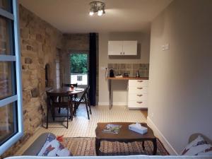 a living room with a table and a kitchen at Manoir du Moustoir - Hôtel Les Empreintes in Saint-Évarzec