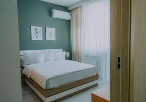 een slaapkamer met een bed en een groene muur bij Horizon Batumi Aparthotel in Batoemi +41 foto's