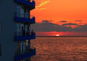 mensen op balkons die vanaf een gebouw naar de zonsondergang kijken bij Horizon Batumi Aparthotel in Batoemi