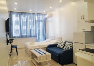 een kleine woonkamer met een bank en een tafel bij Horizon Batumi Aparthotel in Batoemi