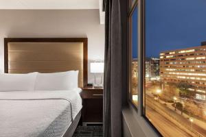a bedroom with a bed and a view of a city at Homewood Suites by Hilton Washington, D.C. Downtown in Washington