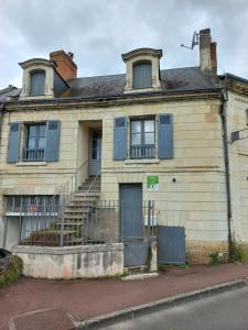 an old house with blue shutters on a street at Agréable maison de ville au coeur de Chinon in Chinon