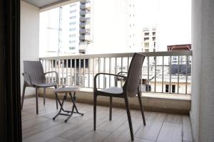 three chairs and a table on a balcony with a window at B RESIDENCE in Beirut
