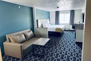 a hotel room with a bed and a couch at Baymont by Wyndham Piqua in Piqua