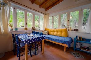a room with a table and a bench and windows at Casa Scirocco Lipari in Lipari