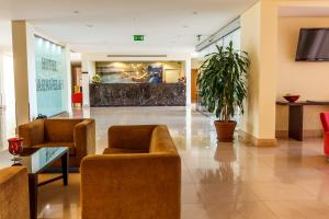 a lobby of a hotel with chairs and a plant at Hotel Caravelas in Madalena