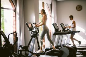 a man and a woman walking on a treadmill in a gym at Jumeirah Bali in Uluwatu