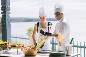 a man and woman preparing food in a kitchen at Jumeirah Bali in Uluwatu