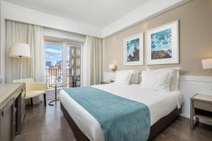 a hotel room with a bed and a balcony at AP Eva Senses in Faro