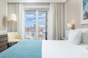 a hotel room with a large bed and a window at AP Eva Senses in Faro