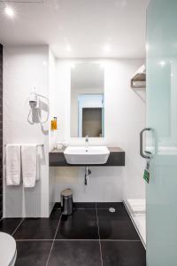 a white bathroom with a sink and a mirror at AP Eva Senses in Faro