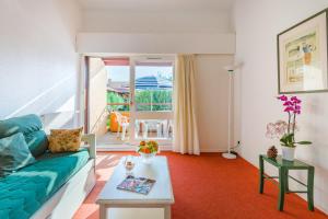 a living room with a couch and a table at Lagrange Vacances Résidence du Golf in Saint-Cyprien