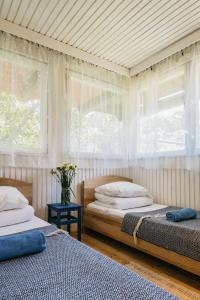 two beds in a room with two windows at Guboja in Nida