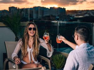 a man and a woman holding glasses of wine at Aparthotel Adagio Malta Central in Msida
