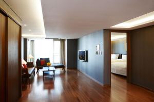 um quarto de hotel com uma cama e uma sala de estar em Oriens Hotel & Residences Myeongdong em Seul