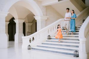 a family walking down the stairs of a house at Jumeirah Bali in Uluwatu