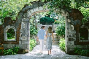 a man and a woman walking through an archway at Jumeirah Bali in Uluwatu