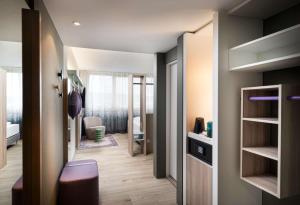 a small room with a hallway with a bedroom at elaya hotel stuttgart ludwigsburg, Trademark by Wyndham in Korntal-Münchingen