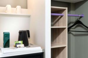 a walk in closet with a coffee maker on a shelf at elaya hotel stuttgart ludwigsburg, Trademark by Wyndham in Korntal-Münchingen +56 photos