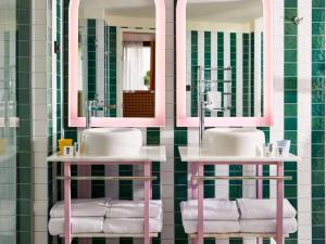 La salle de bains est pourvue de 2 lavabos et de 2 miroirs. dans l'établissement Mama Shelter Dijon, à Dijon