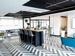 an office lobby with a geometric patterned floor at Mercure Roma Cinecitta in Rome