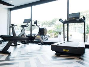 una palestra con tapis roulant e macchinari per il cardio-fitness in camera di Mercure Roma Cinecitta a Roma
