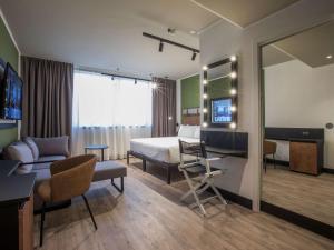 una camera d'albergo con un letto e una scrivania di Mercure Roma Cinecittà a Roma Altre 37 foto