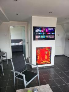 Camera con sedia, TV e letto di City Lounge an der Feuerwache mit Außenbereich mit Klimaanlage a Wolmirstedt