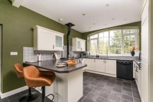 - une cuisine avec des murs verts et un comptoir dans l'établissement Malham Wellbeing 1-bed Retreat With Hot Tub, à Malham