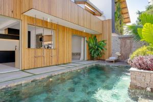 an indoor swimming pool in the backyard of a house at Villa Mango Beach, face au lagon de l'Ermitage in La Saline les Bains