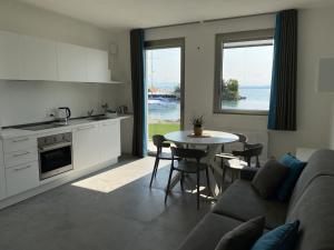 a kitchen and living room with a couch and a table at Sirmio Apartments - Darsena Stay in Sirmione