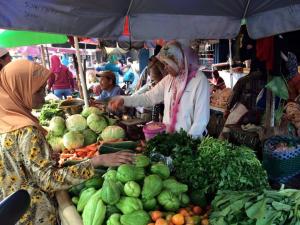 twee vrouwen staan op een markt met groenten bij Griya Harja Homestay in Borobudur