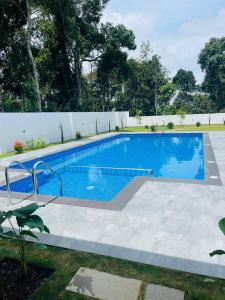 a swimming pool in a backyard with a white fence at The Windy Mist Resort Munnar in Chinnakanal