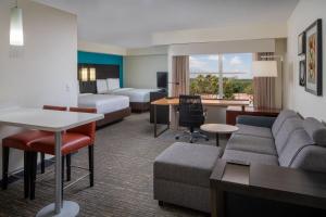 a hotel room with a couch and a bed at Residence Inn Orlando Convention Center in Orlando