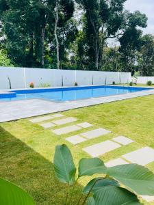 a swimming pool in a yard next to a fence at The Windy Mist Resort Munnar in Chinnakanal