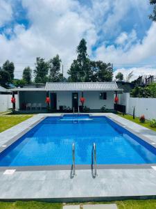 a swimming pool in front of a house at The Windy Mist Resort Munnar in Chinnakanal