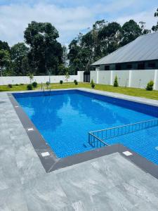 a large swimming pool with blue water at The Windy Mist Resort Munnar in Chinnakanal