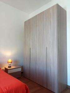 um grande armário de madeira num quarto com uma cama vermelha em Granatelli Holiday Home em Altavilla Milicia