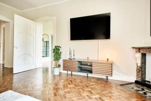 シュトルベルクにあるExklusives Altbauapartment - zentral und ruhigの壁にテレビが掛かっているリビングルーム