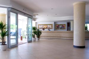 a lobby of a building with pillars and plants at Roses Hotel in Roseto degli Abruzzi